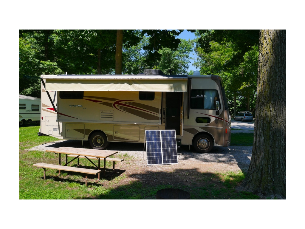 Exterior image of Winnebago Vista in camp with portable solar panels on display