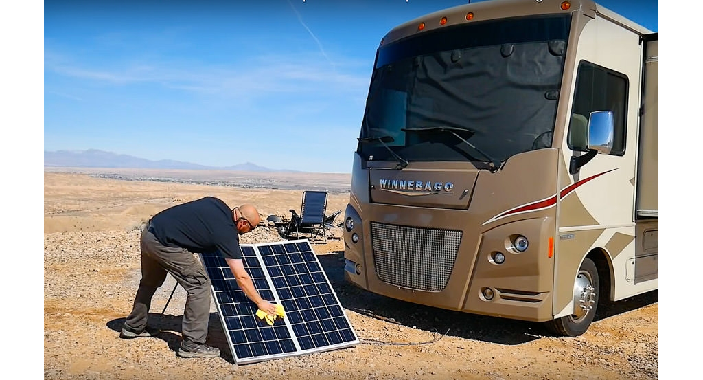 Man cleans portable solar panels 