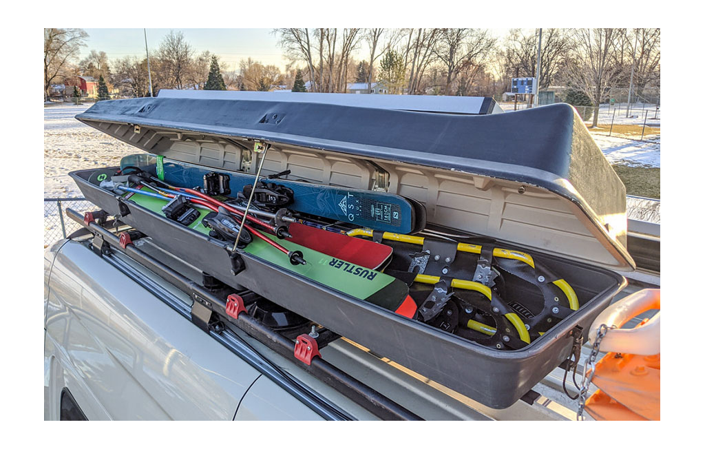 Roof top box with skis and snowshoes in it on top of Winnebago Revel.