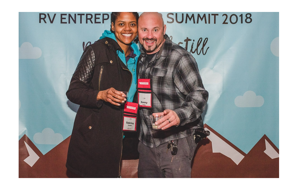 Sabrina and Kenny in front of sign at RVE Summit