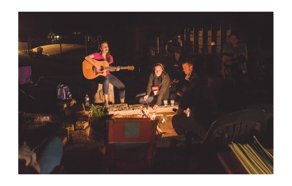 Summit attendees sitting around a campfire for a sing-along