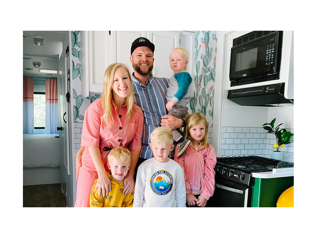 Wages family smiling for a photo inside their newly renovated Minnie Winnie