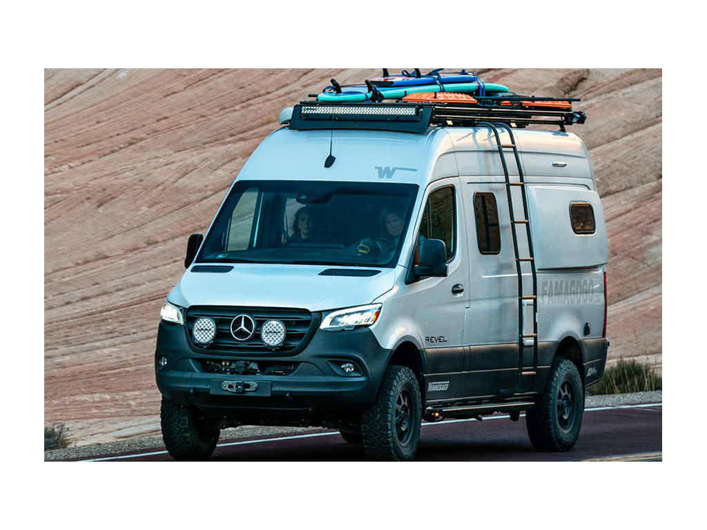 Kathy driving Revel with Abby in passenger seat. Dual roof rack is on top of Revel