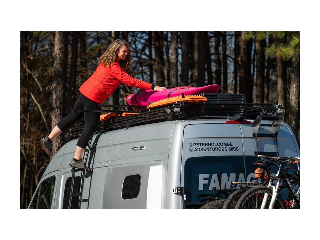 Kathy placing kayak on Black River Dual Roof Rack