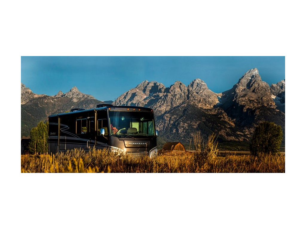 Adventurer sounded by yellow grass and tall mountains with barn in far distance