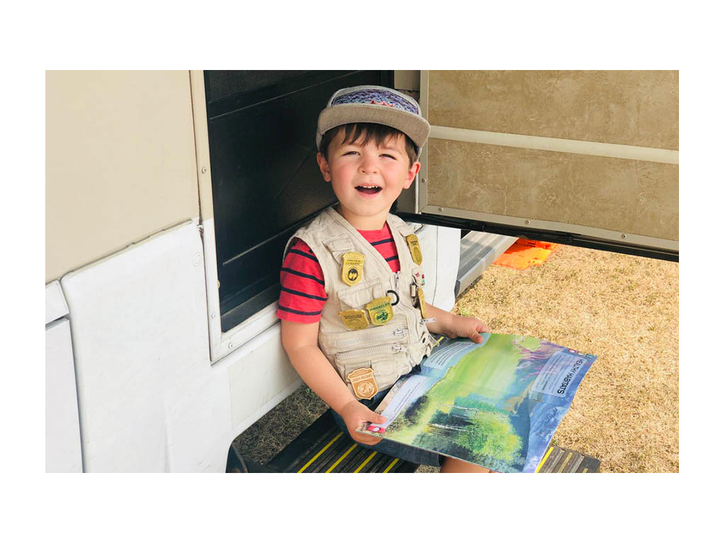 Caspian sitting on View steps reading junior ranger book