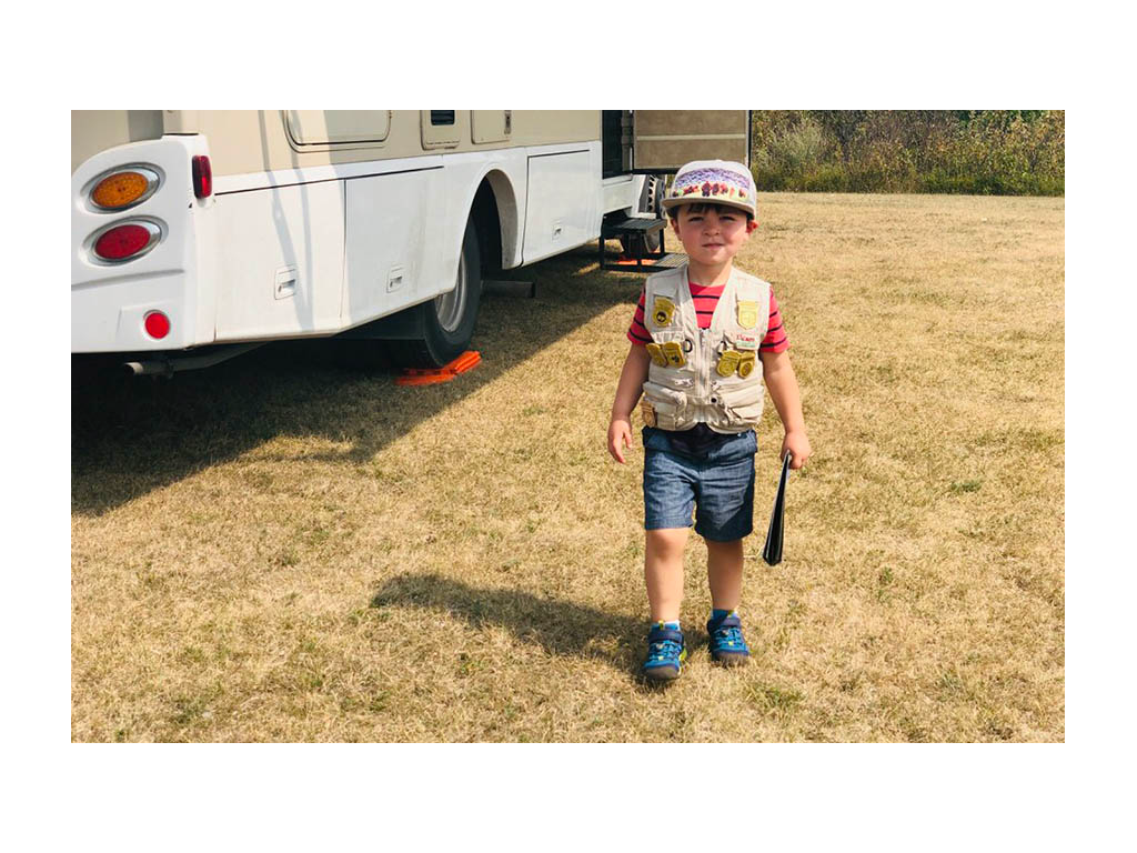 Caspian wearing ranger vest standing next to Winnebago View