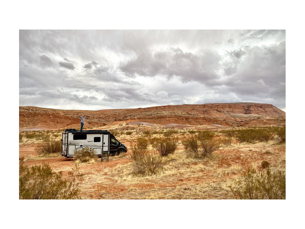 James standing on top of EKKO parked in desert