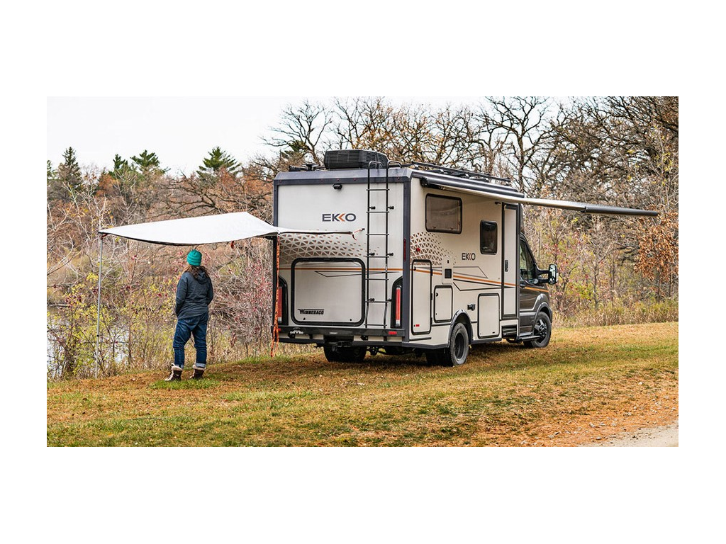 Exterior of EKKO with both awnings out. Kathy Holcombe is standing under one awning with hands in pockets.