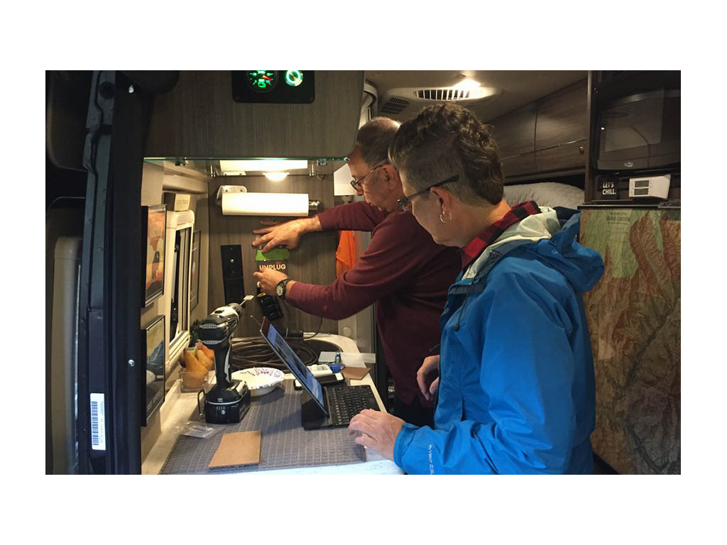 Greg and Noel mentoring Noel. Both are standing in Travato galley.