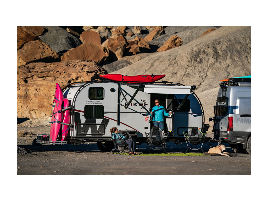 Kathy standing in door of Winnebago HIKE while Abby and Tucker the dog sit outside