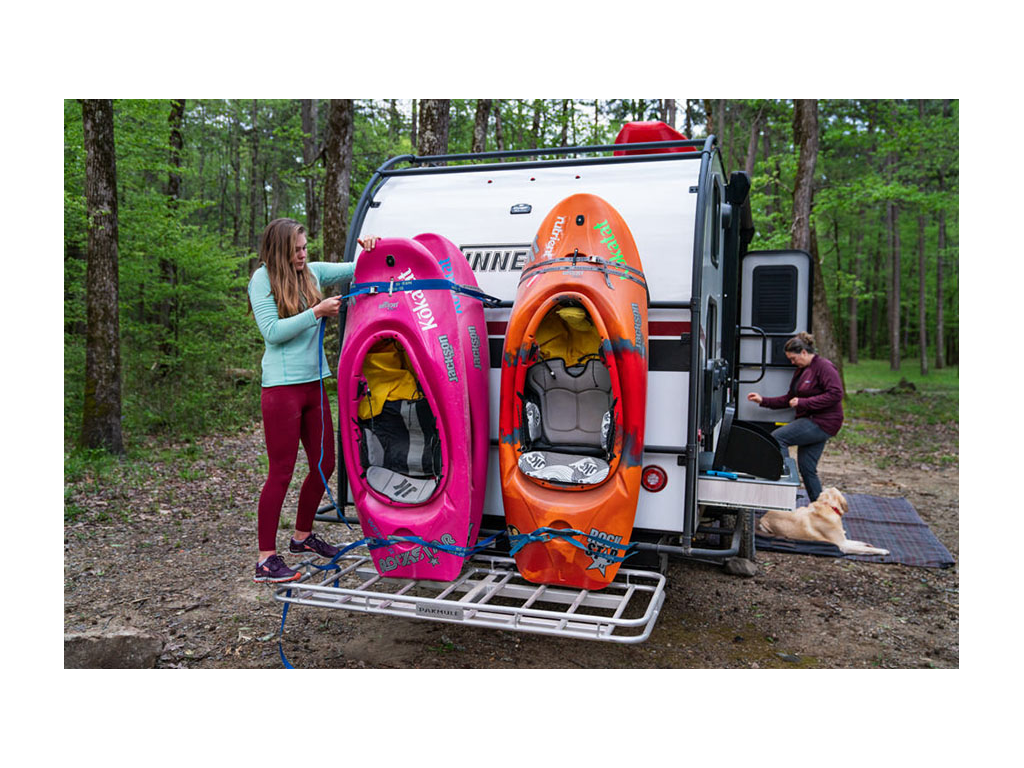 Kathy stepping inside HIKE while Abby is on back strapping in kayaks