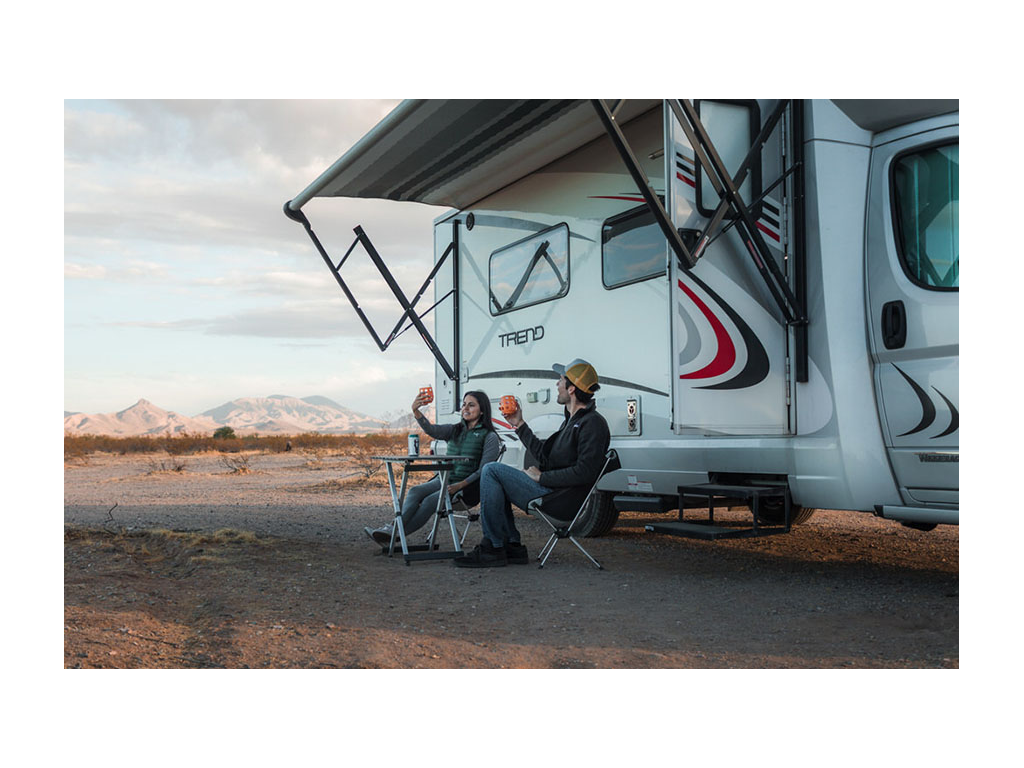 Nadia and Jon sitting outside of Trend at table drinking wine under awning