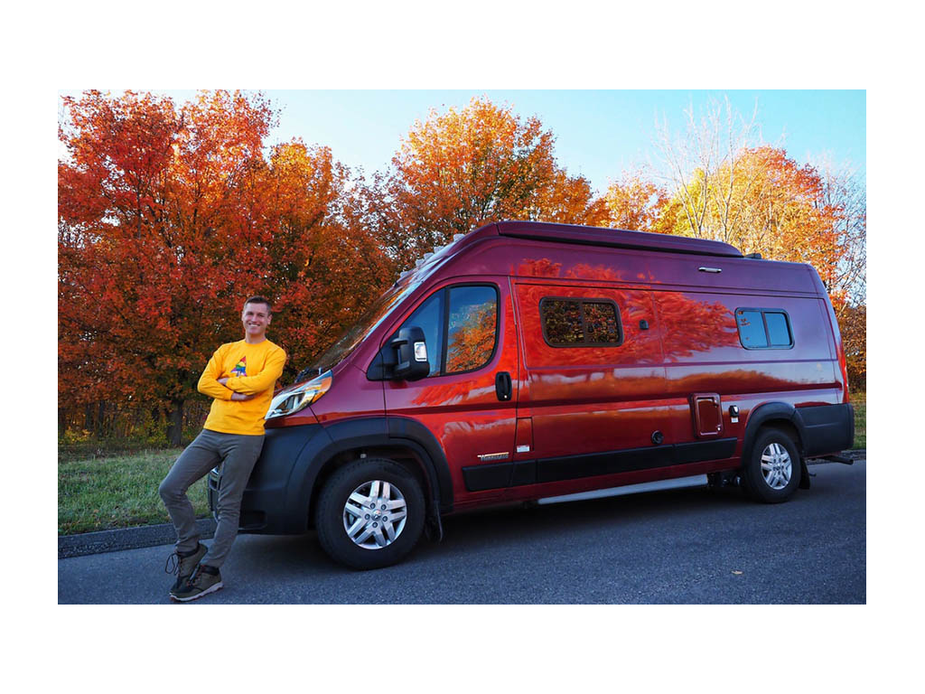 Mikah leaning against bumper of Winnebago Solis