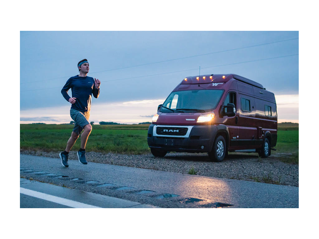 Mikah running on road with Solis parked with lights on