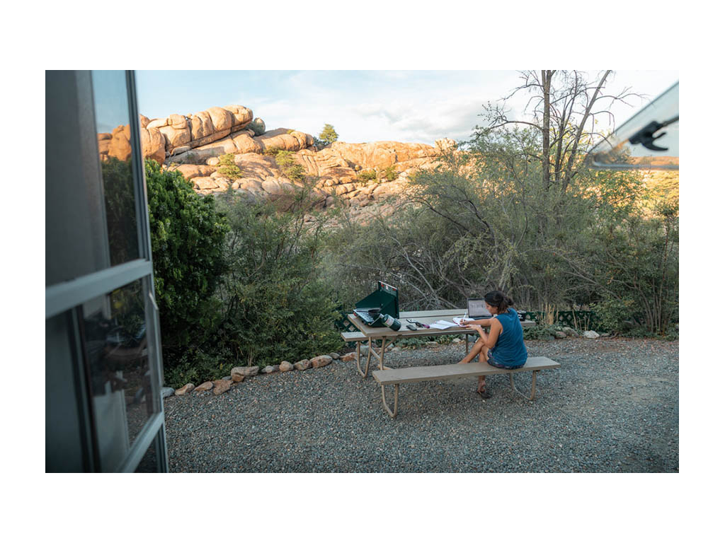 Nadia sitting outside of Trend working on laptop at picnic table