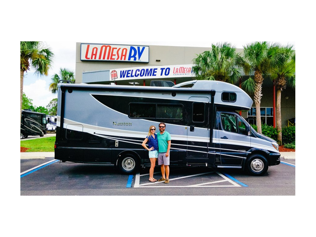 Katelyn and Howard smiling in front of Navion at La Mesa RV