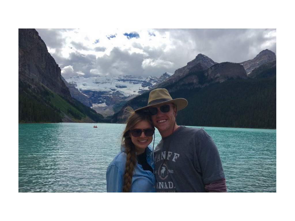 Alyssa and Heath smiling in front of water and mountains in Banff National Park