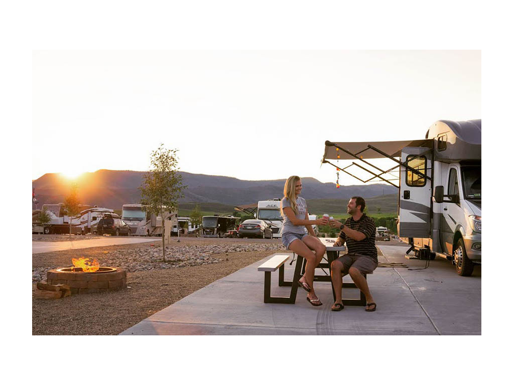 Lindsay and Dan having drinks at picnic table outside of Winnebago Navion