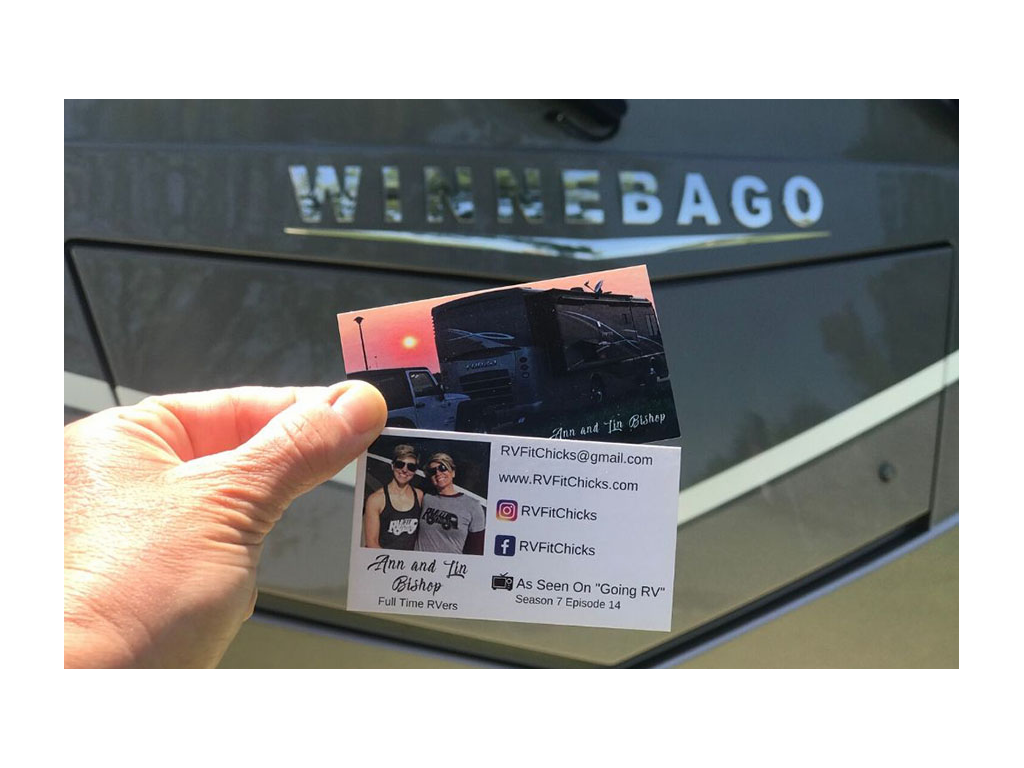 Card with contact information held up in front of Winnebago Forza