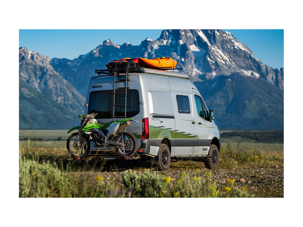 Revel with dirt bike on bike rack with Teton mountains in background