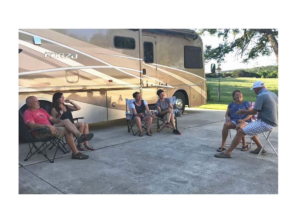 Ann & Lin sitting in front of Forza with friends at a distance