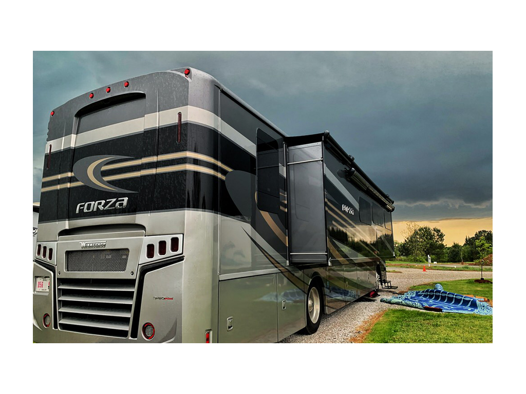 Forza parked on gravel with dark skies overhead