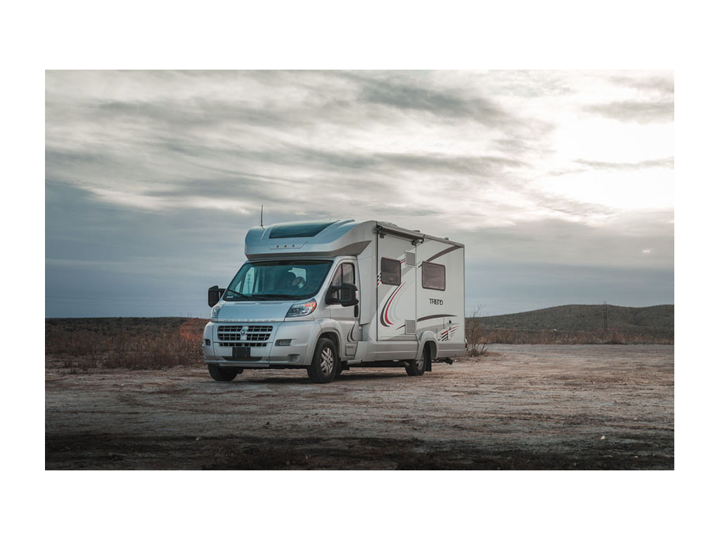 Winnebago Trend parked on gravel with sunset in background