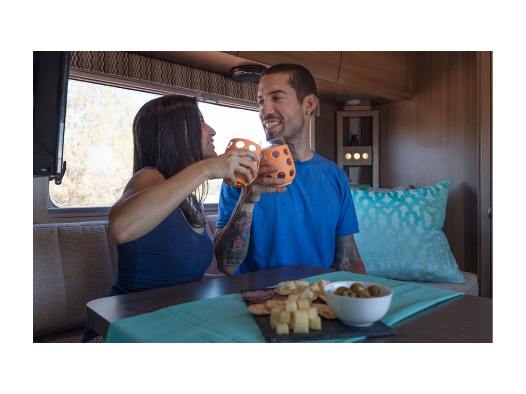 Nadis and Jon drinking wine at dinette with plate of cheese on table