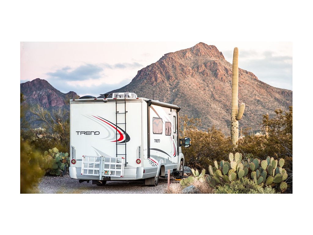 Trend parked on gravel near mountains and saguaro cacti