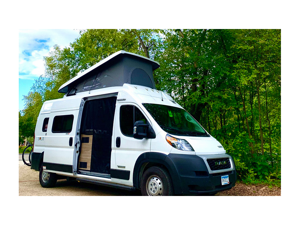 Winnebago Solis parked next to trees with pop-top up