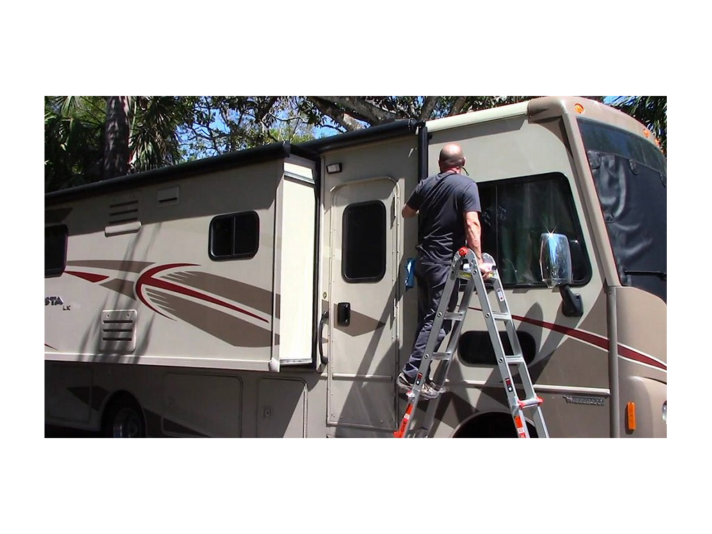 Kenny standing on ladder to inspect RV window seals