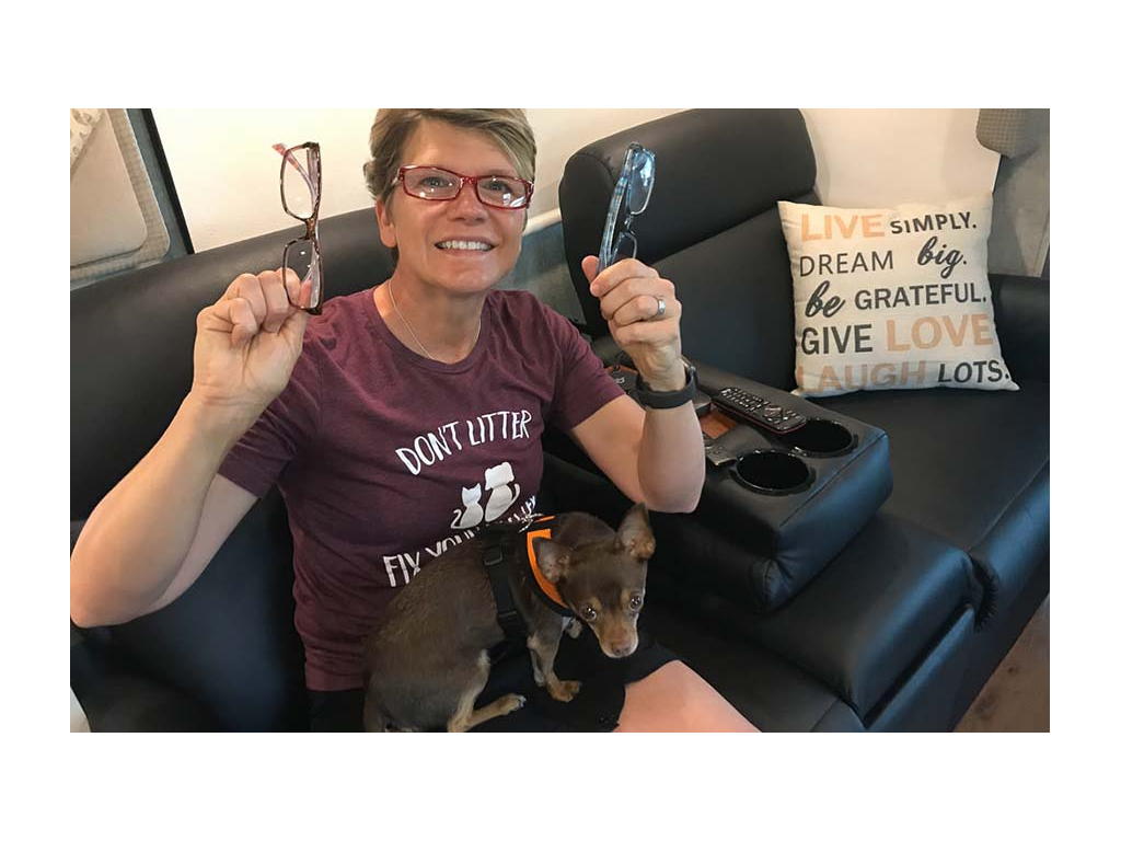 Lin holding up two pairs of glasses while Wally sits on her lap