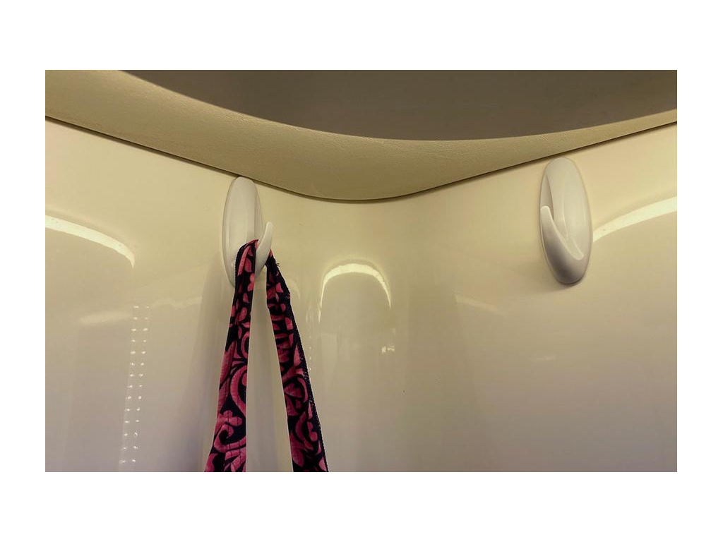 Two 3M Command Hooks on shower wall with pink and black bag handing on one hook