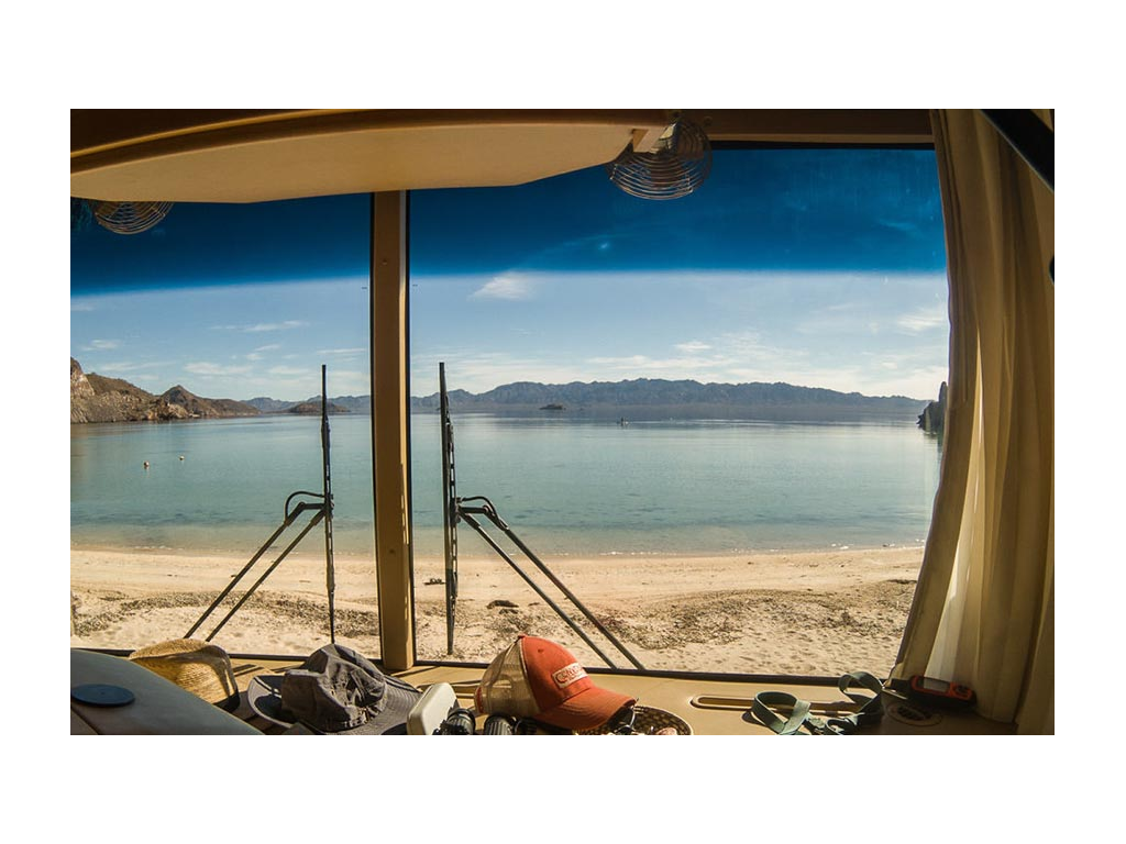 View of beach and water out of windshield of Journey