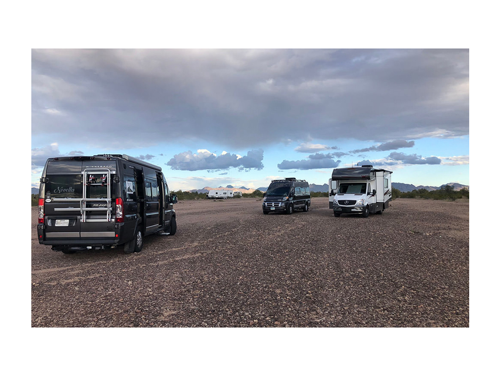 Two Travatos and a Vita parked on gravel