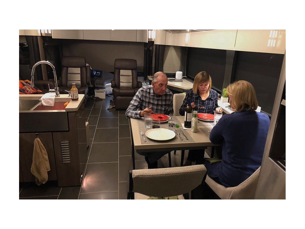 Three people eating at kitchen table