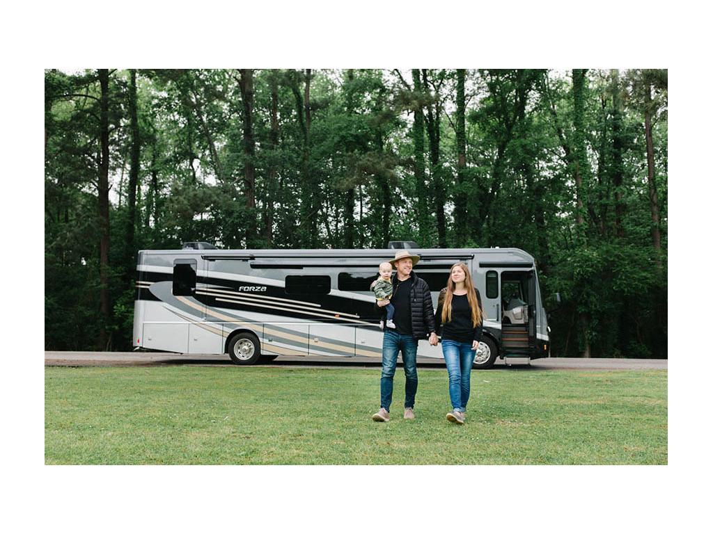 Heath, Alyssa and Ellie walking in grass with Forza parked in the background