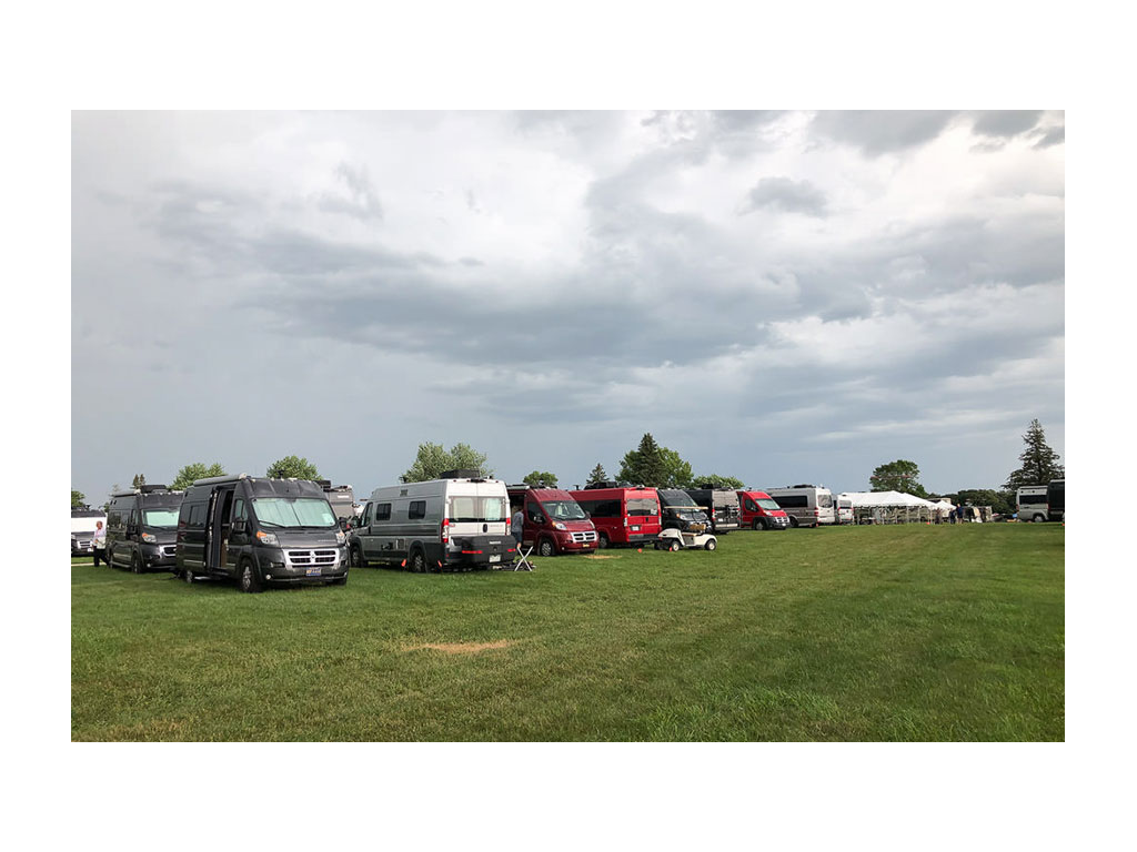 Travatos of every color parked in a line on the grass during the Grand National Rally