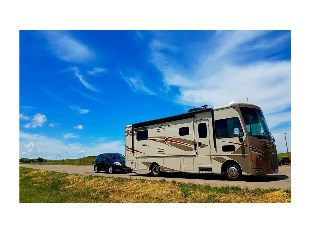Winnebago Vista pulling tow car down road