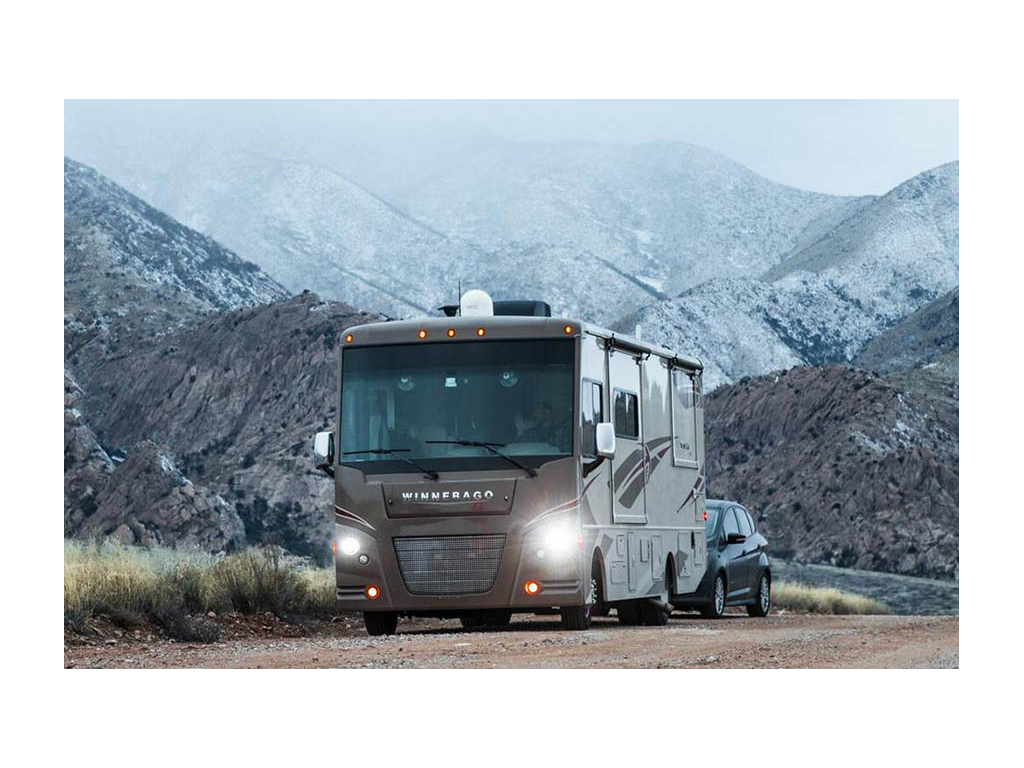 Vista pulling tow car with snow capped mountains in background