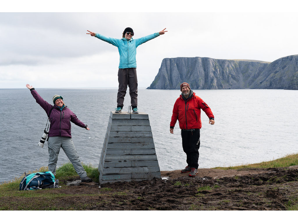 The Holcombe family standing at edge of shore with water in the background