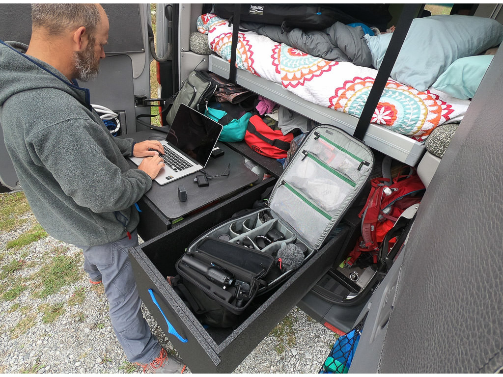 Peter at the back of the Winnebago Revel displaying their custom drawer system