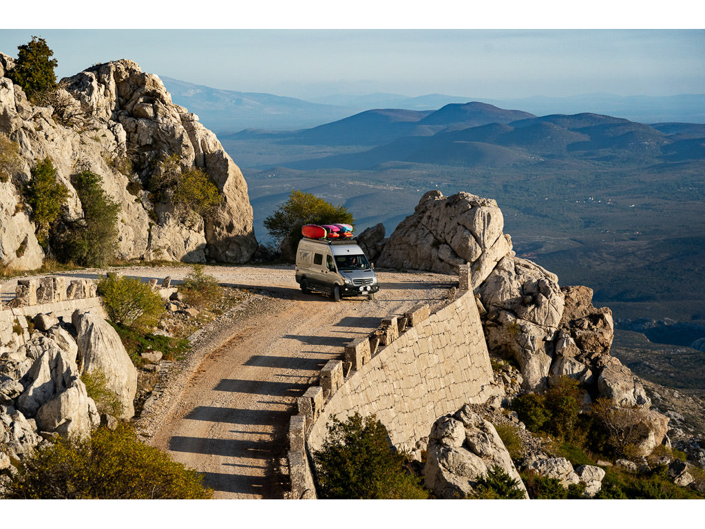 Winnebago Revel driving on rock surrounded high road in Croatia