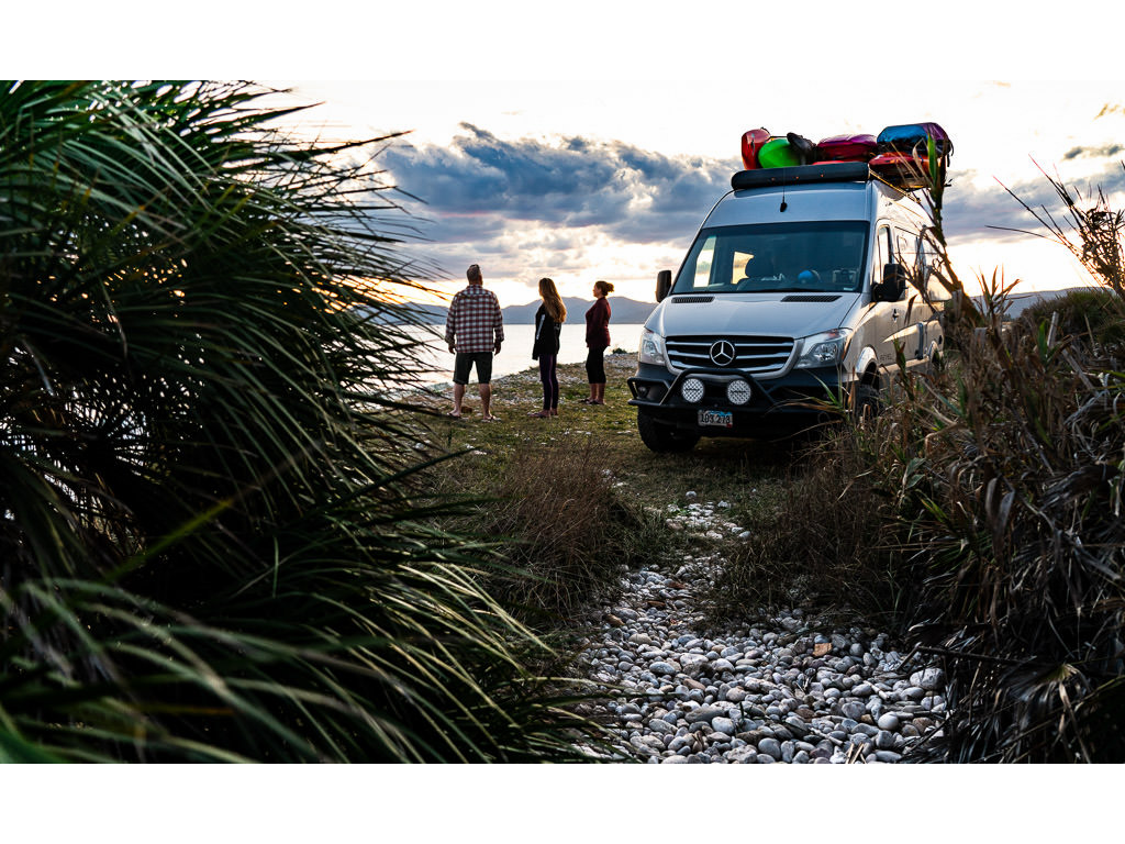 Winnebago Revel parked with Holcombe family overlooking beautiful body of water