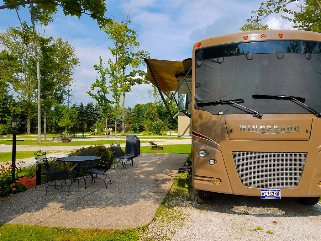 Winnebago Vista parked at KOA site with nice patio furniture next to the motorhome