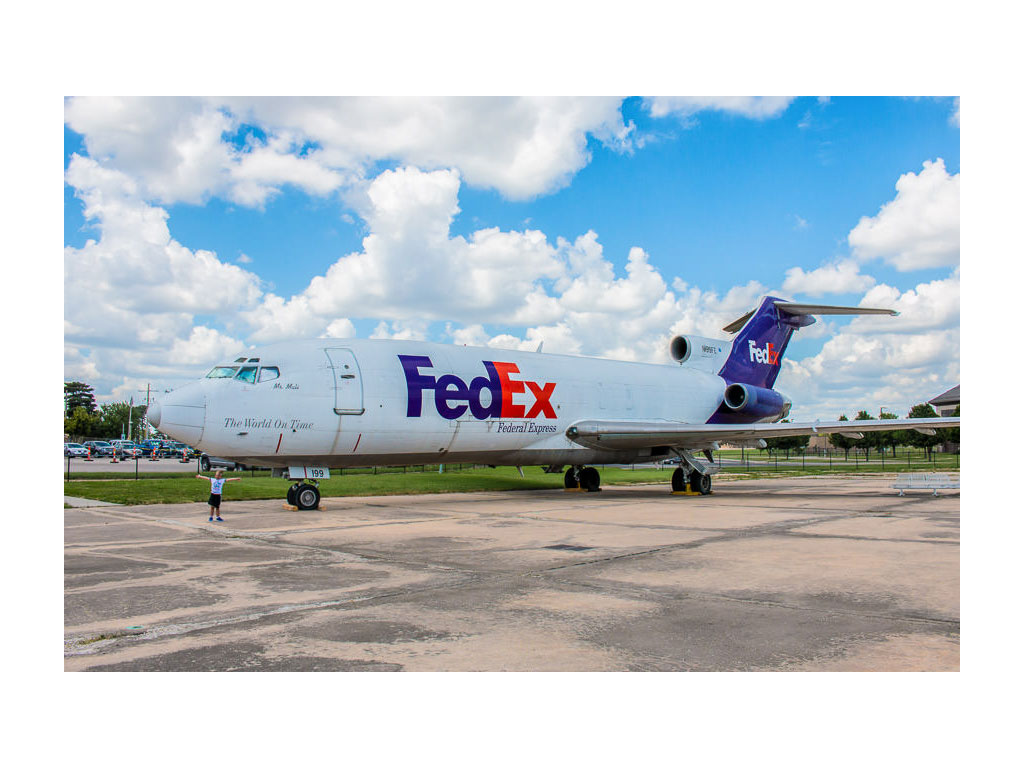 One of the boys next to a FedEx plane at the Kansas Aviation Museum