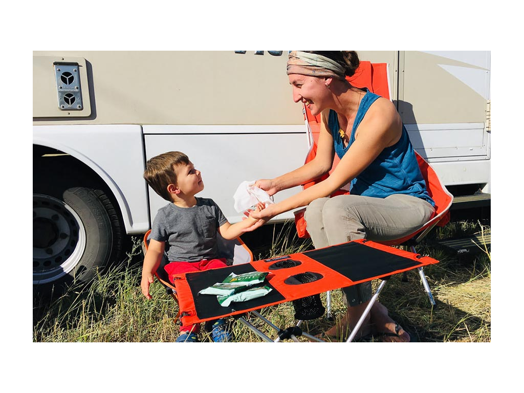 Brittany cleaning off Caspian's hands while sitting at a table in front of View