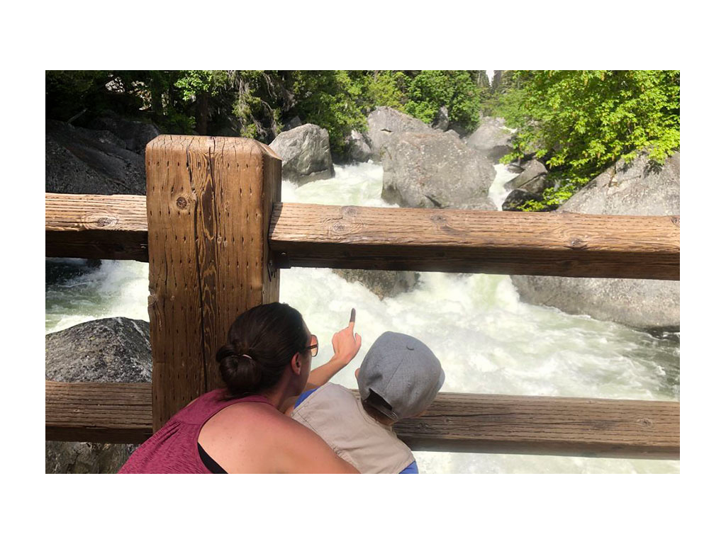 Brittany and Caspian looking through wooden bridge at water