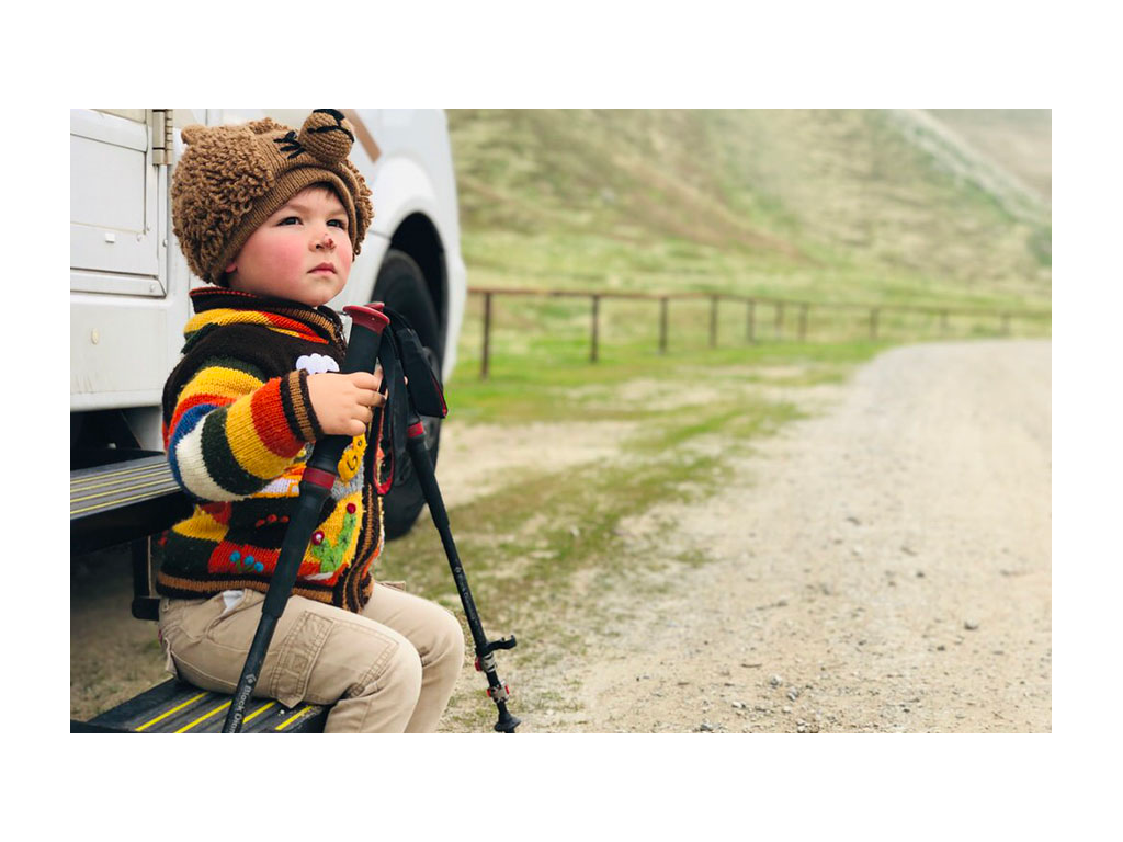 Caspian sitting on Via steps holding hiking sticks